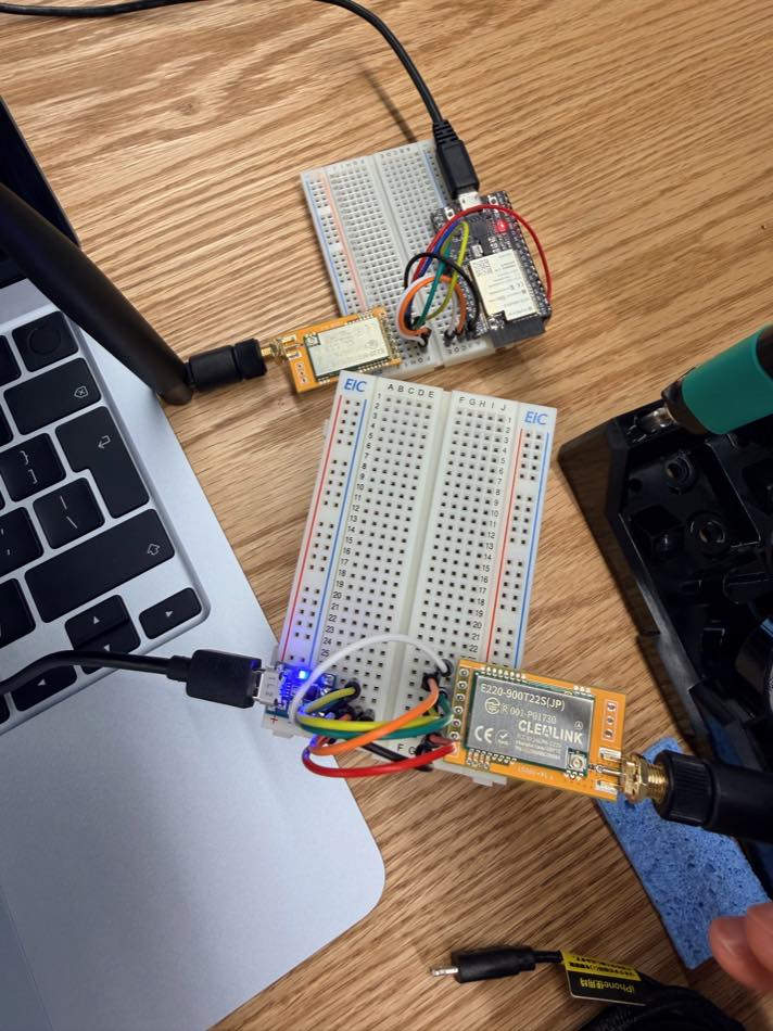 机の上に並んだ ESP32 と LoRa モジュールの通信試験環境