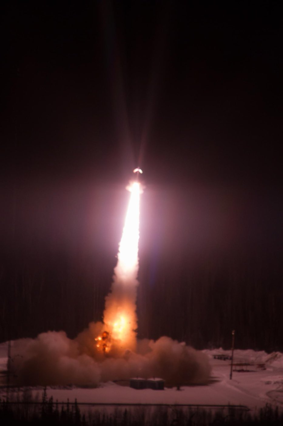 アラスカの雪原から夜空へ立ち上がる観測ロケットの炎の柱